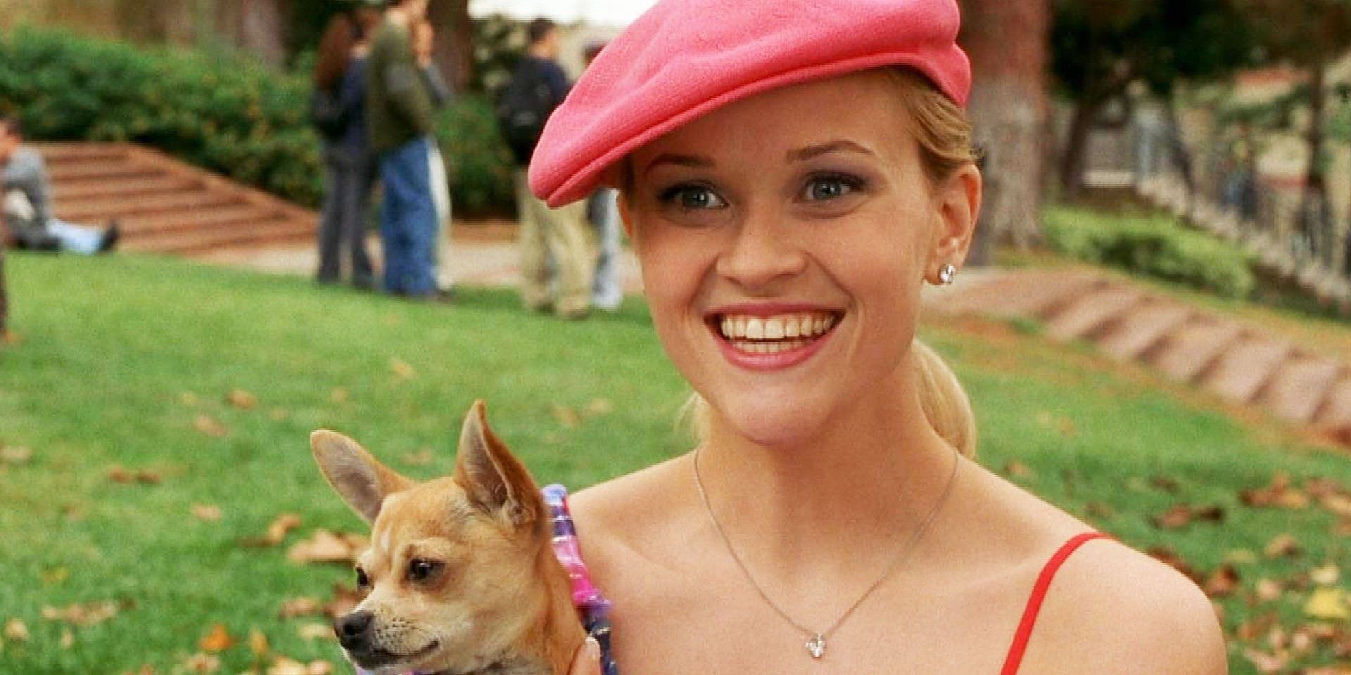 Elle Woods (Reese Witherspoon) sorri segurando Bruiser em Legalmente Loira