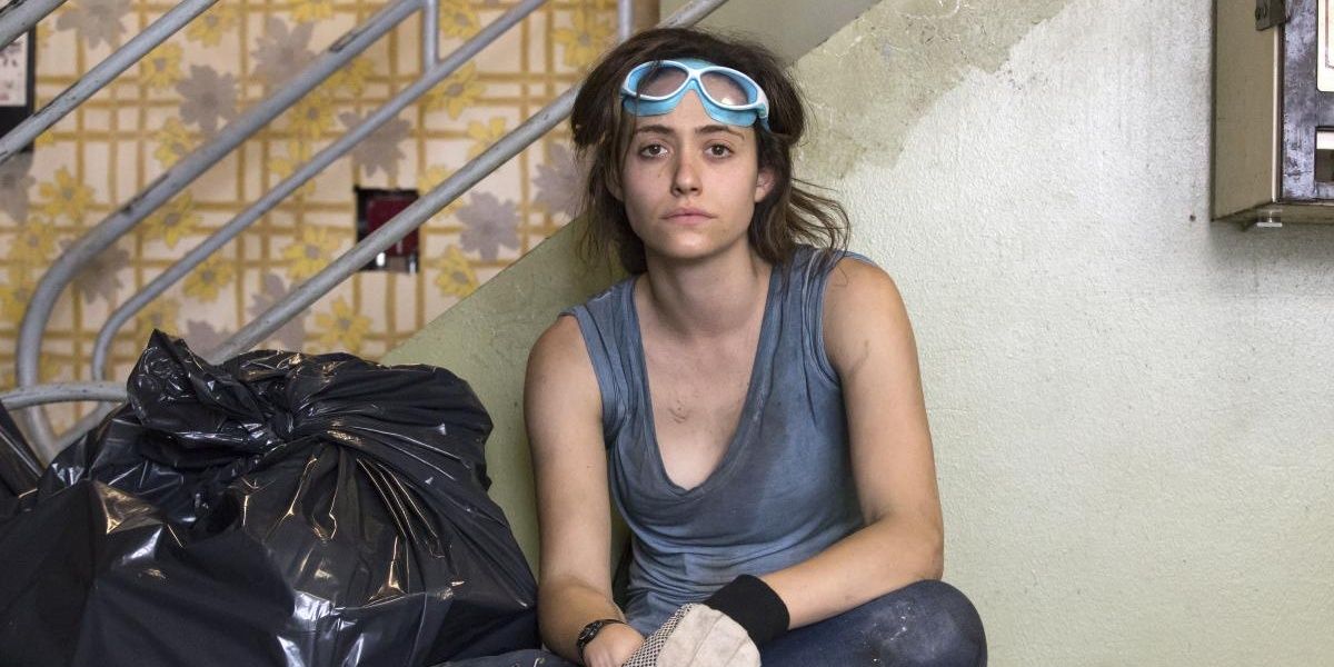 Fiona Gallagher from Shameless Sits in her laundromat looking tired and filthy, protective goggles on her forehead