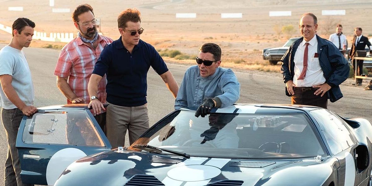 Christian Bale and Matt Damon standing next to a car in Ford V Ferrari