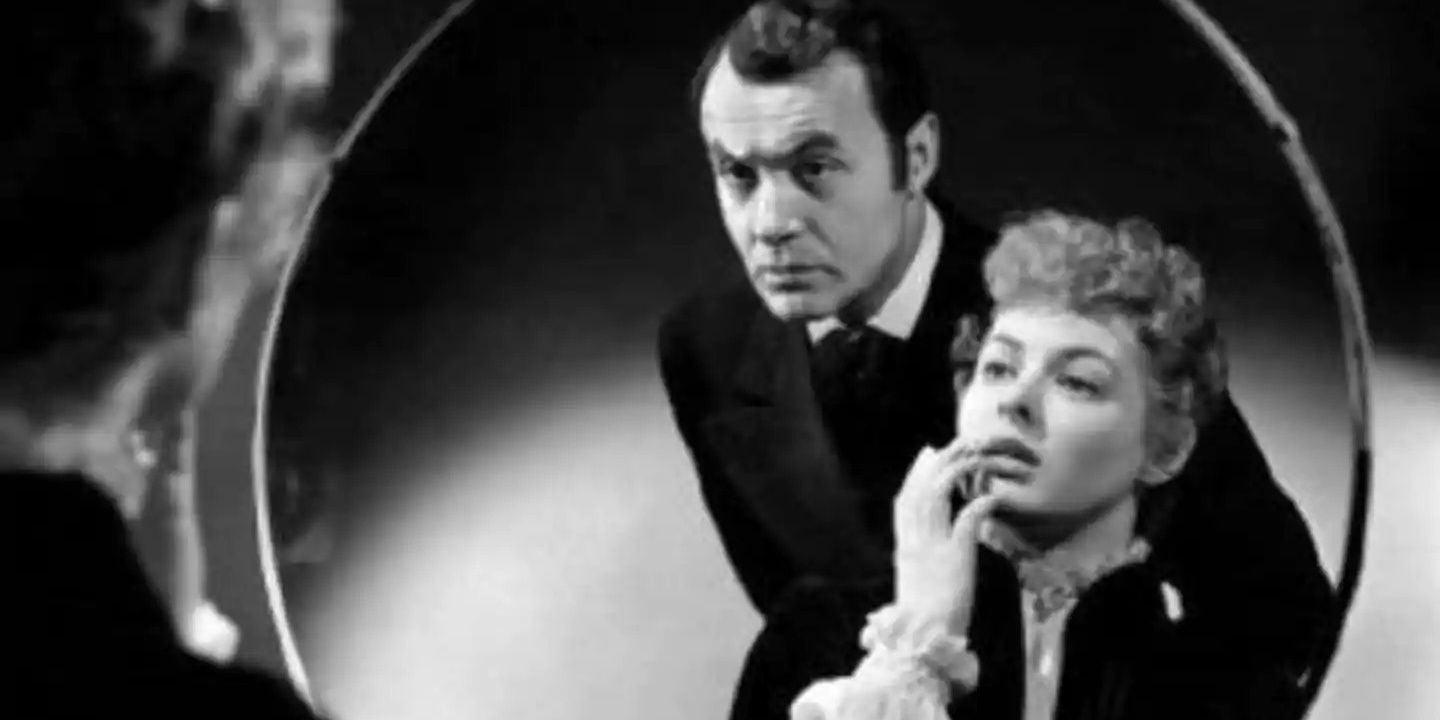 Paula and Gregory look into a mirror in Gaslight