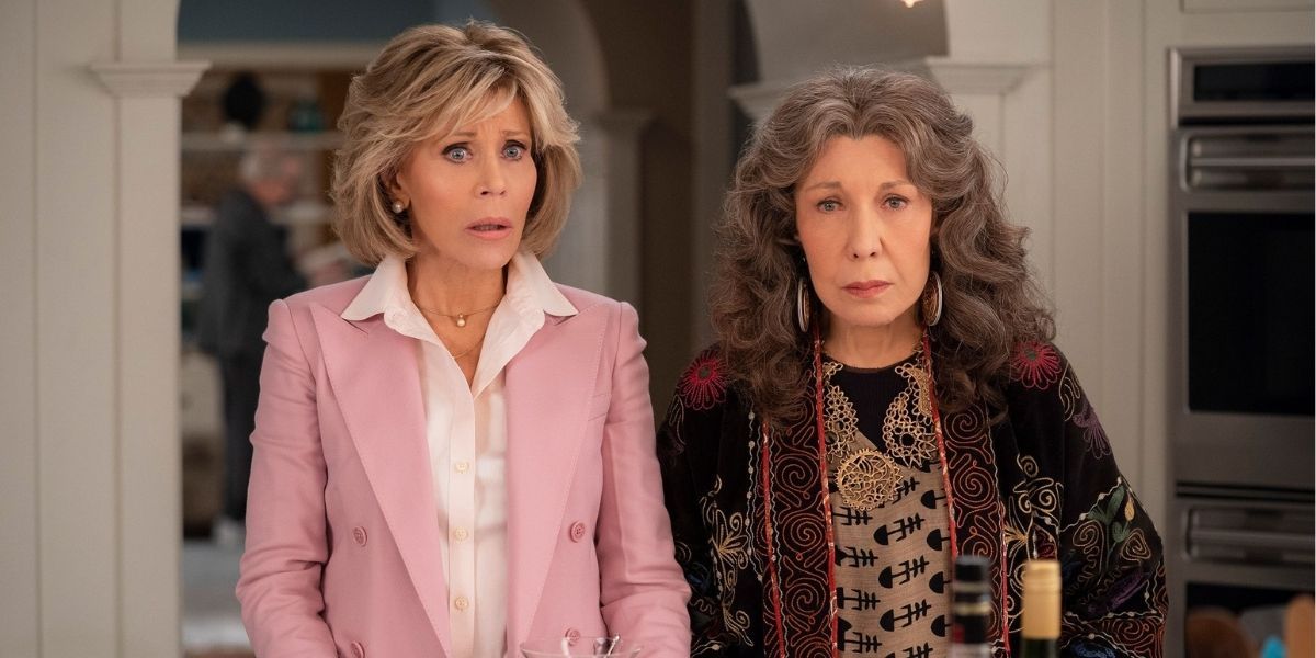 Grace and Frankie looking shocked standing in their kitchen