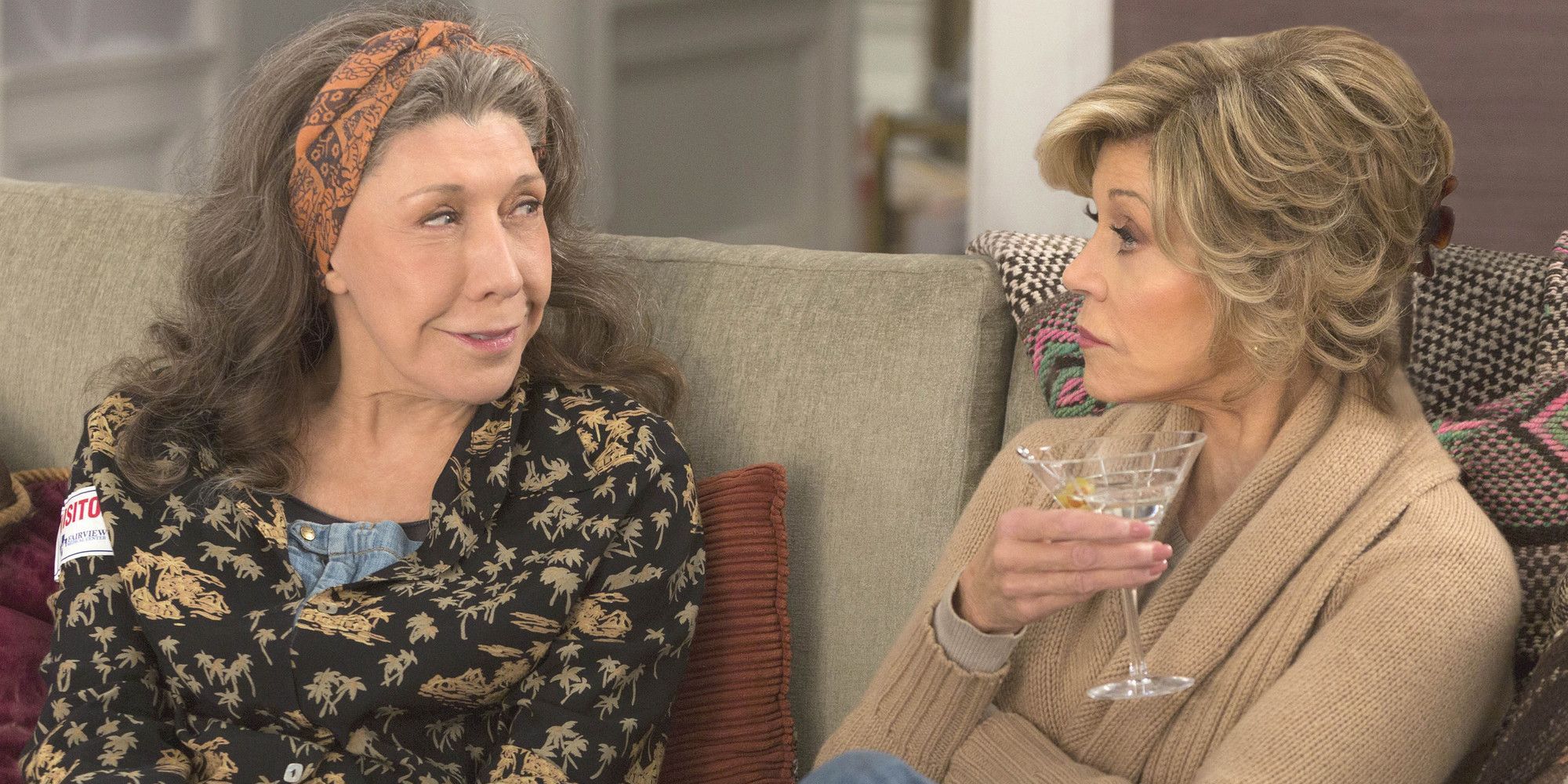 Grace and Frankie smiling at each other