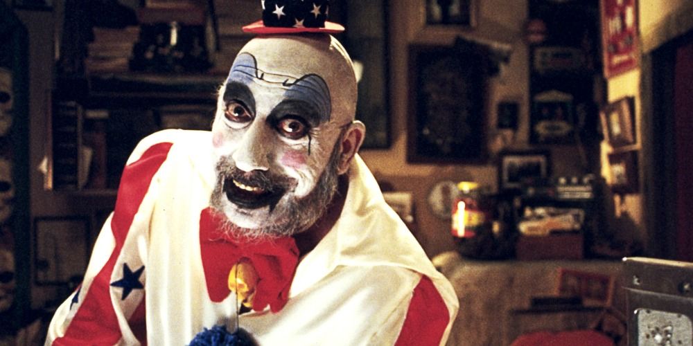 Captain Spaulding leaning on a counter and smiling at the camera in House of 1,000 Corpses