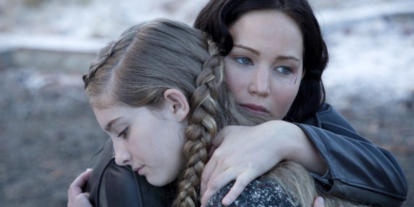 Prim and Katniss hugging outside in the snow From The Hunger Games 
