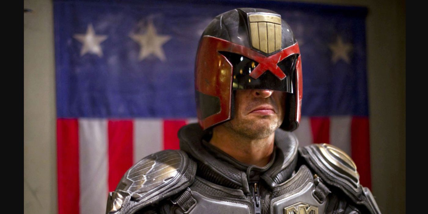 Judge Dredd stands in front of an American flag in Dredd