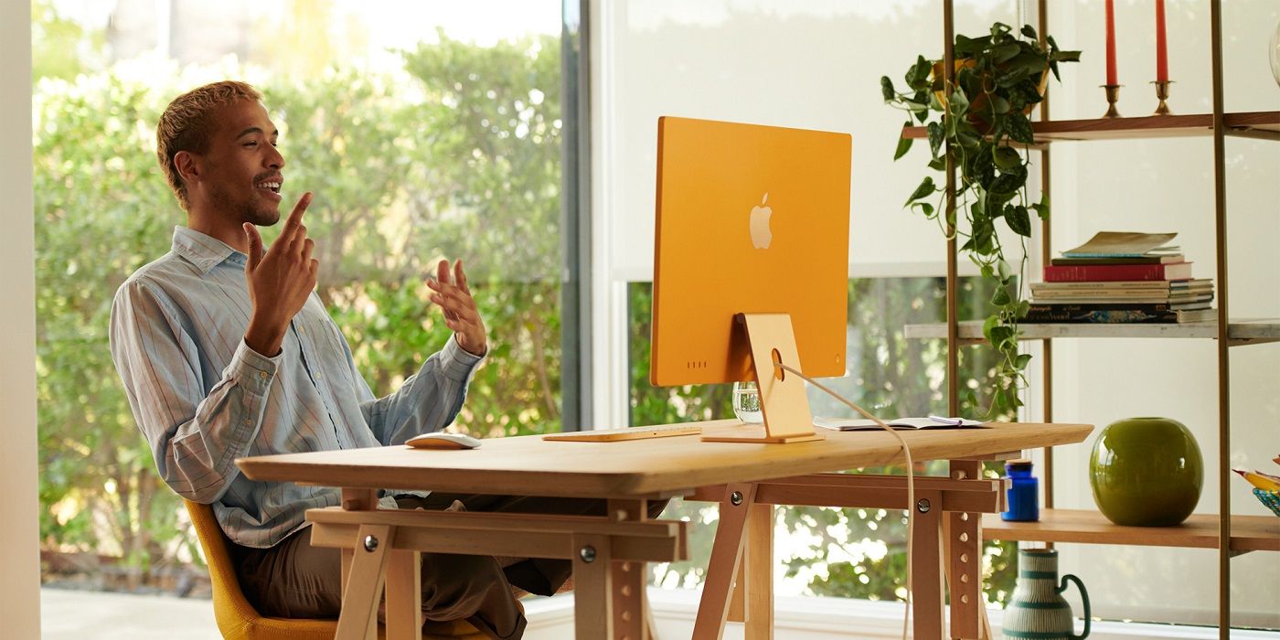A photo of person using a yellow M1 iMac 2021
