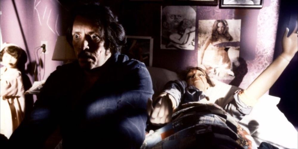 Frank Zito sitting on his bed in the dark with a female mannequin behind him in Maniac