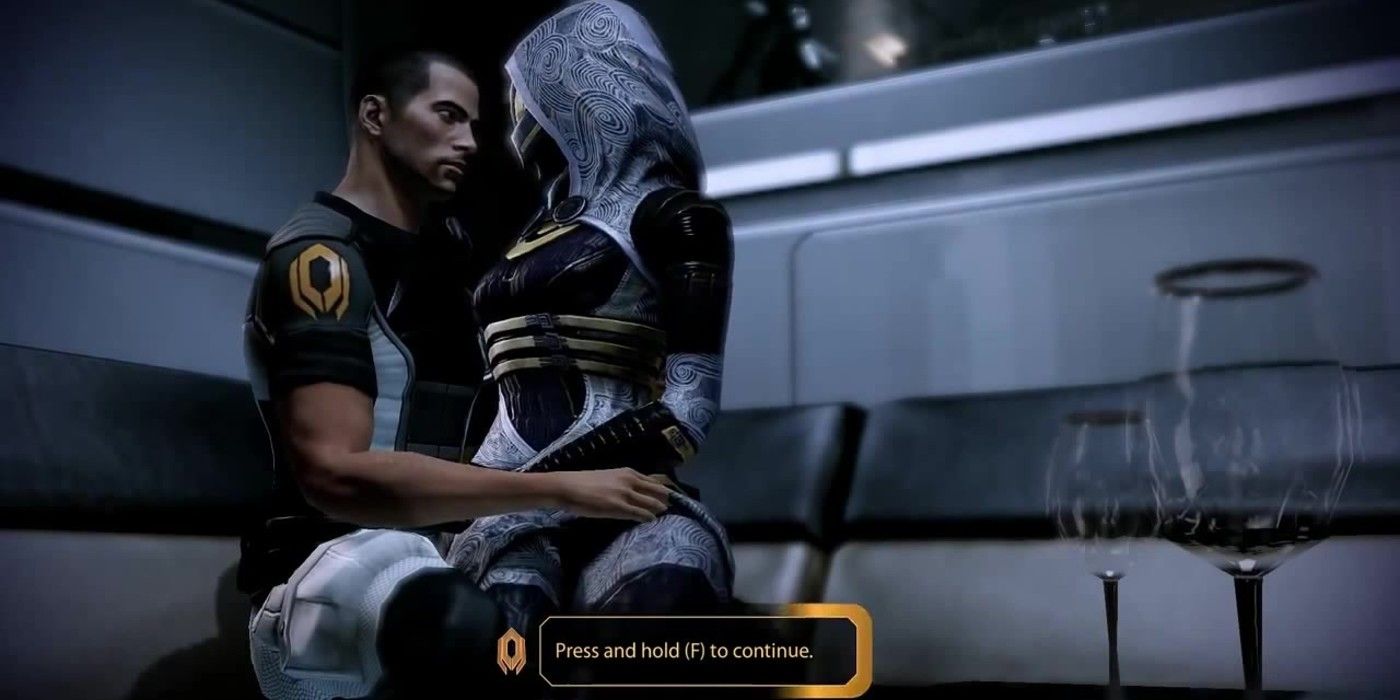 Shepard and Tali cuddle on the couch in the Captain's Cabin in Mass Effect 2