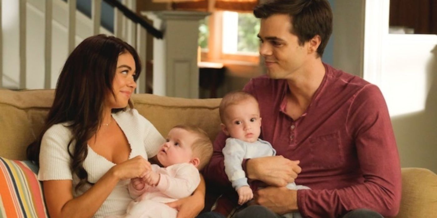 Haley e Dylan segurando seus bebês gêmeos no sofá em Modern Family
