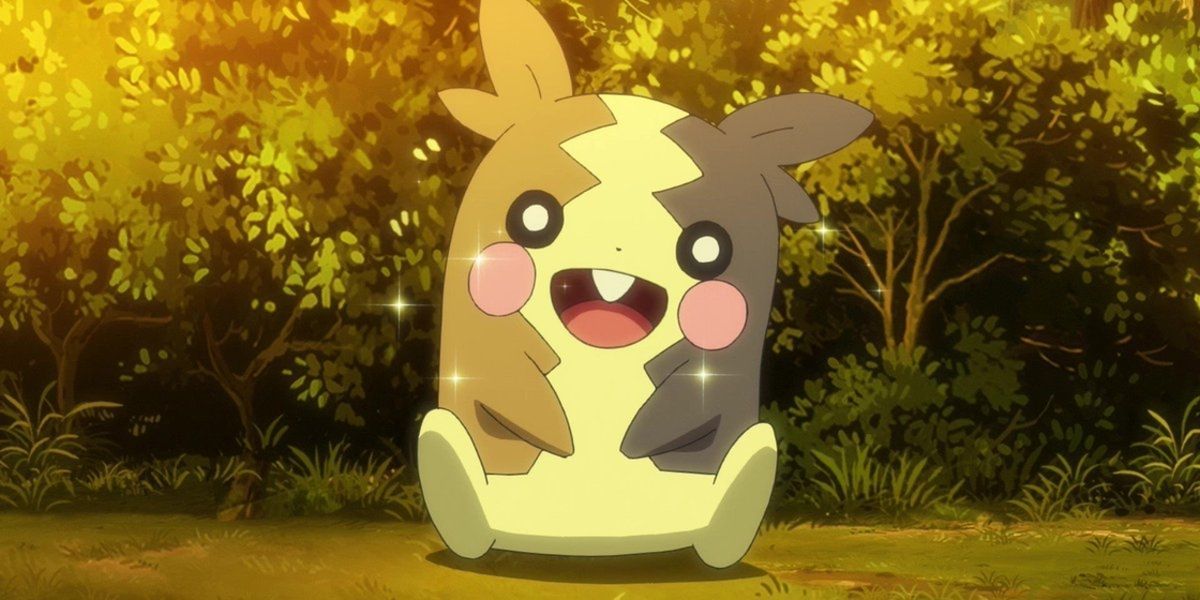A smiling Morpeko sitting on the grass in the Pokémon anime