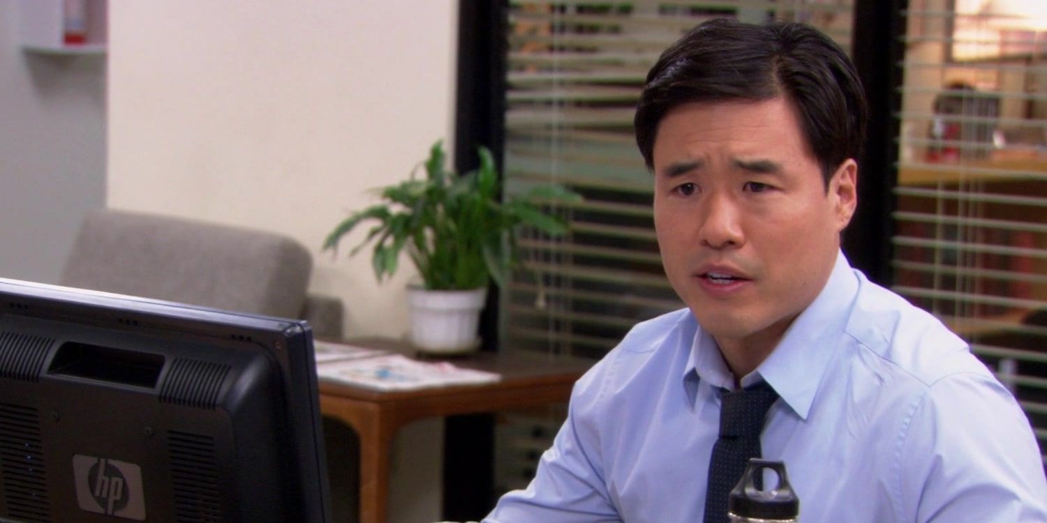 Randall Park sitting by a computer in The Office