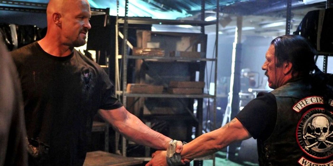 Steve Austin grabs Danny Trejo's arm in Recoil.