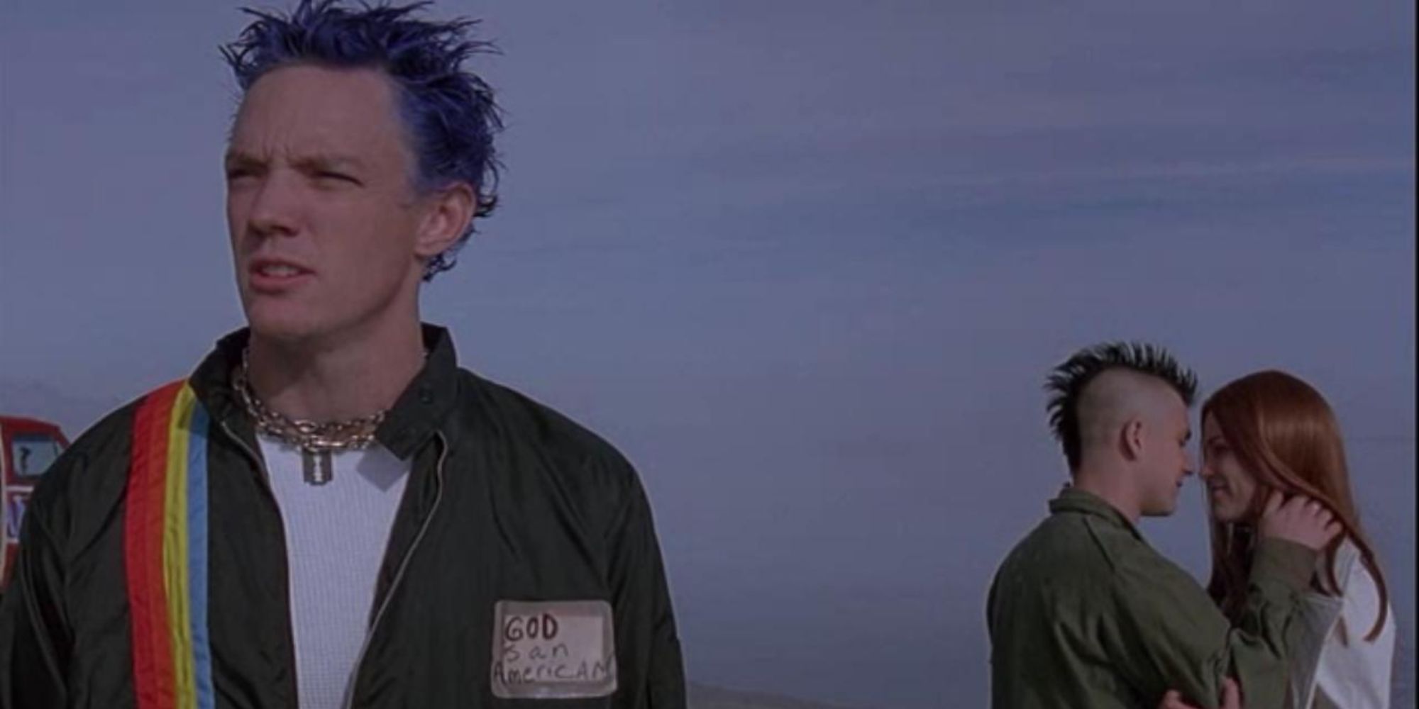 Stevo standing in front of Heroin and Trish in SLC Punk