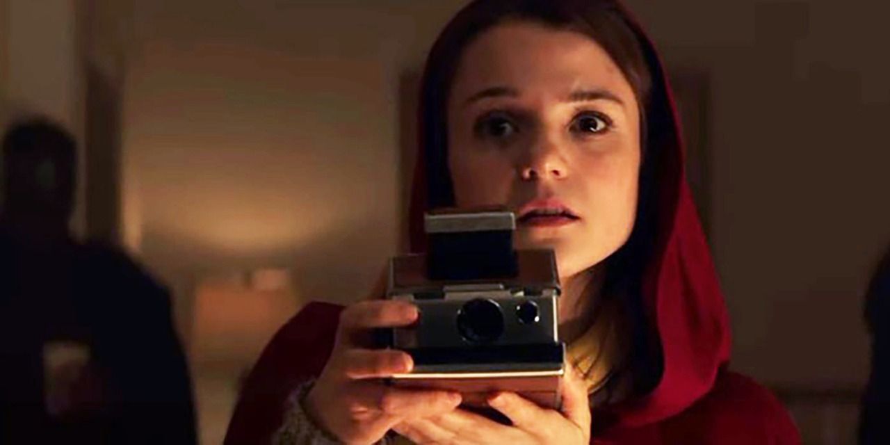 Kathryn Prescott holding a camera in Polaroid