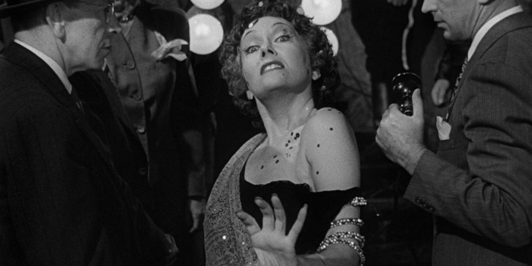 Norma Desmond looking into the camera as the press swarm