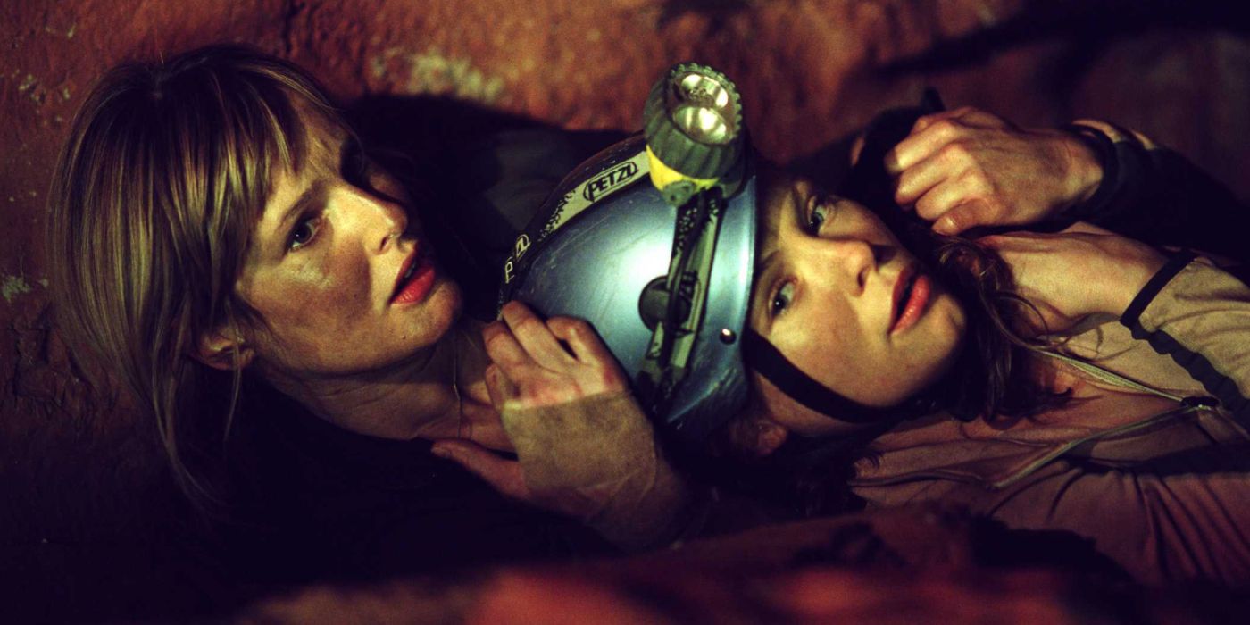 Two female characters wrestling on the ground in The Descent