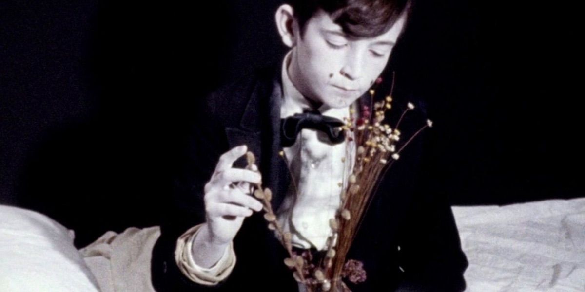 Young boy in David Lynch's The Grandmother wearing suit and bow tie and white makeup.