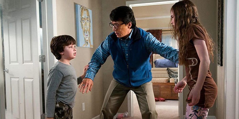 Jackie Chan and kids in the house corridor in The Spy Next Door, looking worried and frantic.