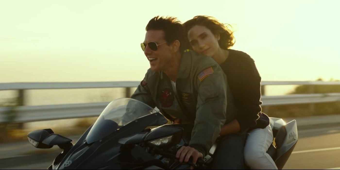 Tom Cruise laughs as he drive a motorcycle with Jennifer Connelly in Top Gun Maverick