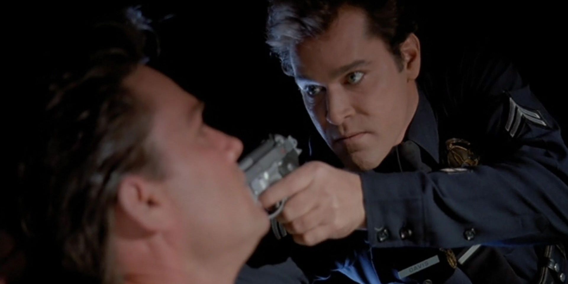 Ray Liotta as a police officer with a gun to Kurt Russell's head in a car in Unlawful Entry