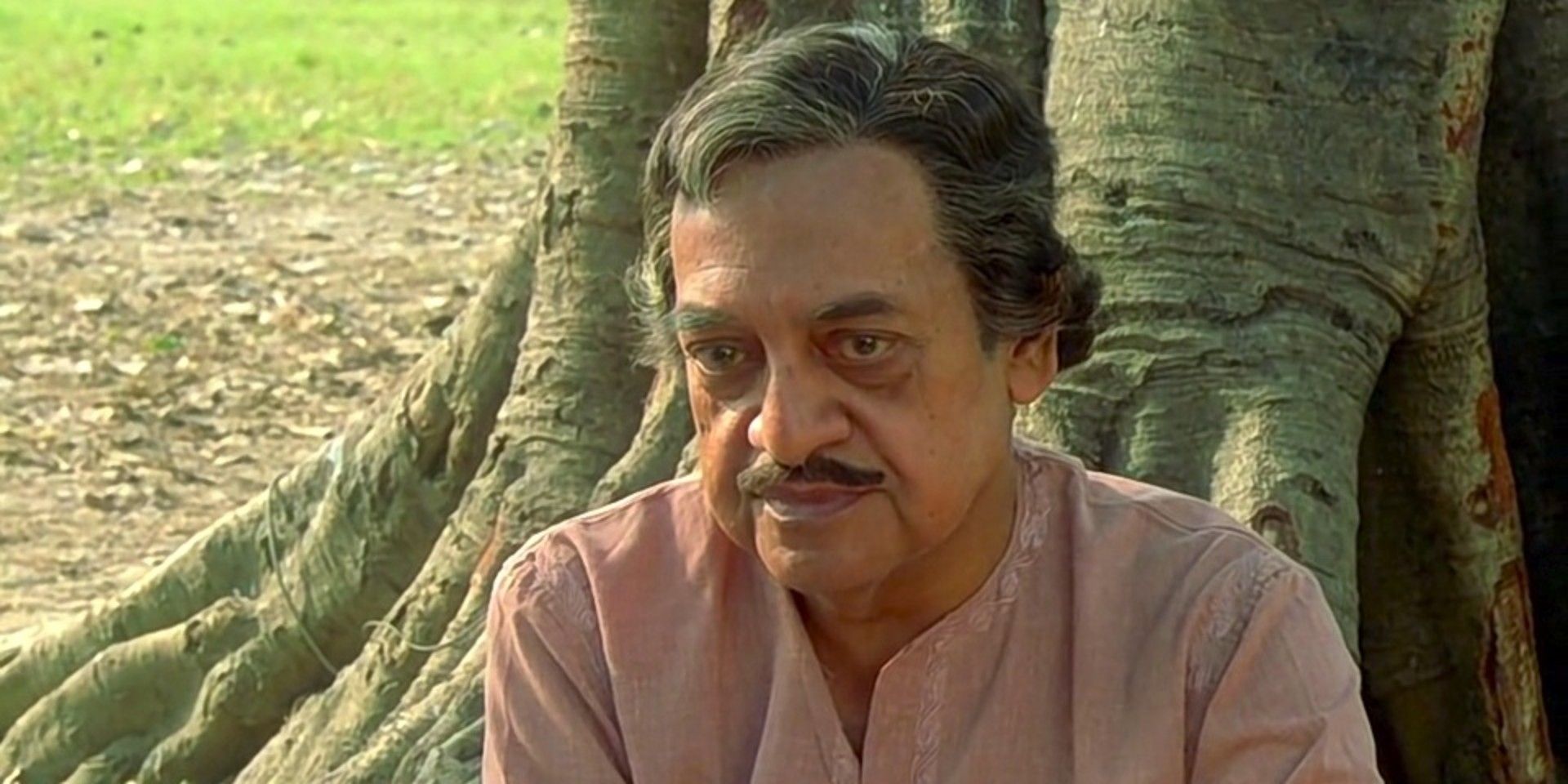 Utpal Dutt sitting near a tree in The Stranger 1991