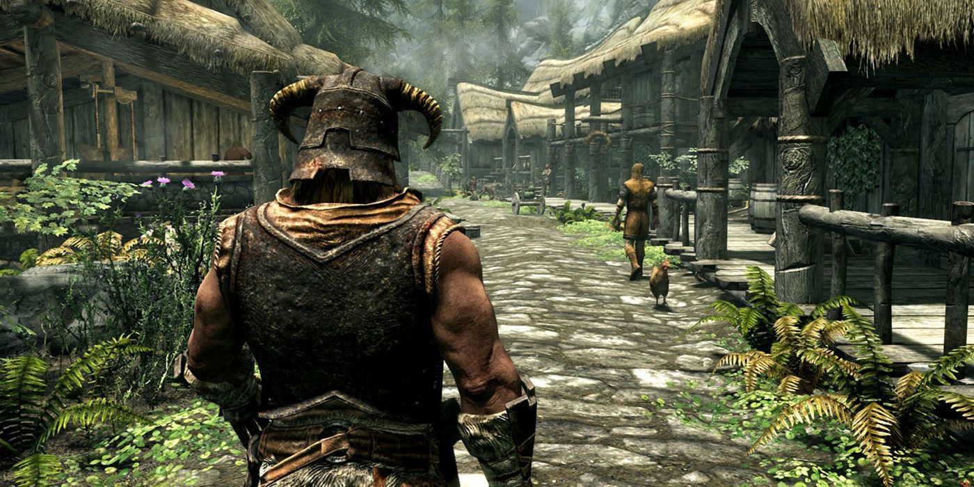 A third-person shot of a Skyrim player dressed as the Dragonborn walks through the sunny town of Riverwood.