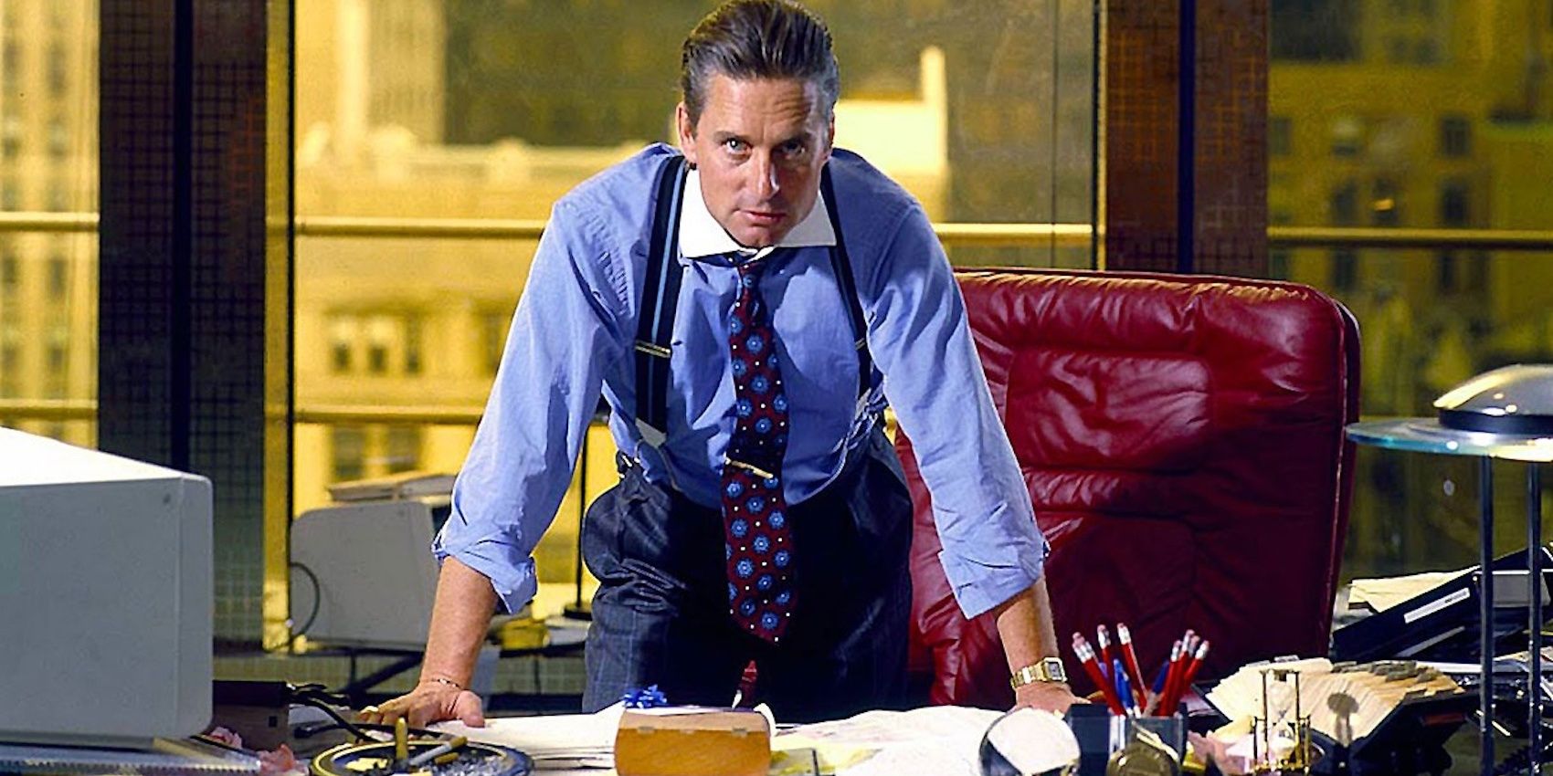 Michael Douglas as Gordon Gekko behind desk in Wall Street