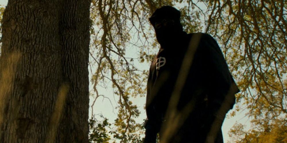 The Zodiac killer standing near a tree in Zodiac