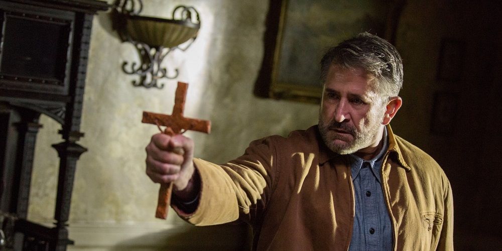 Samuel extends crucifix in Annabelle Creation