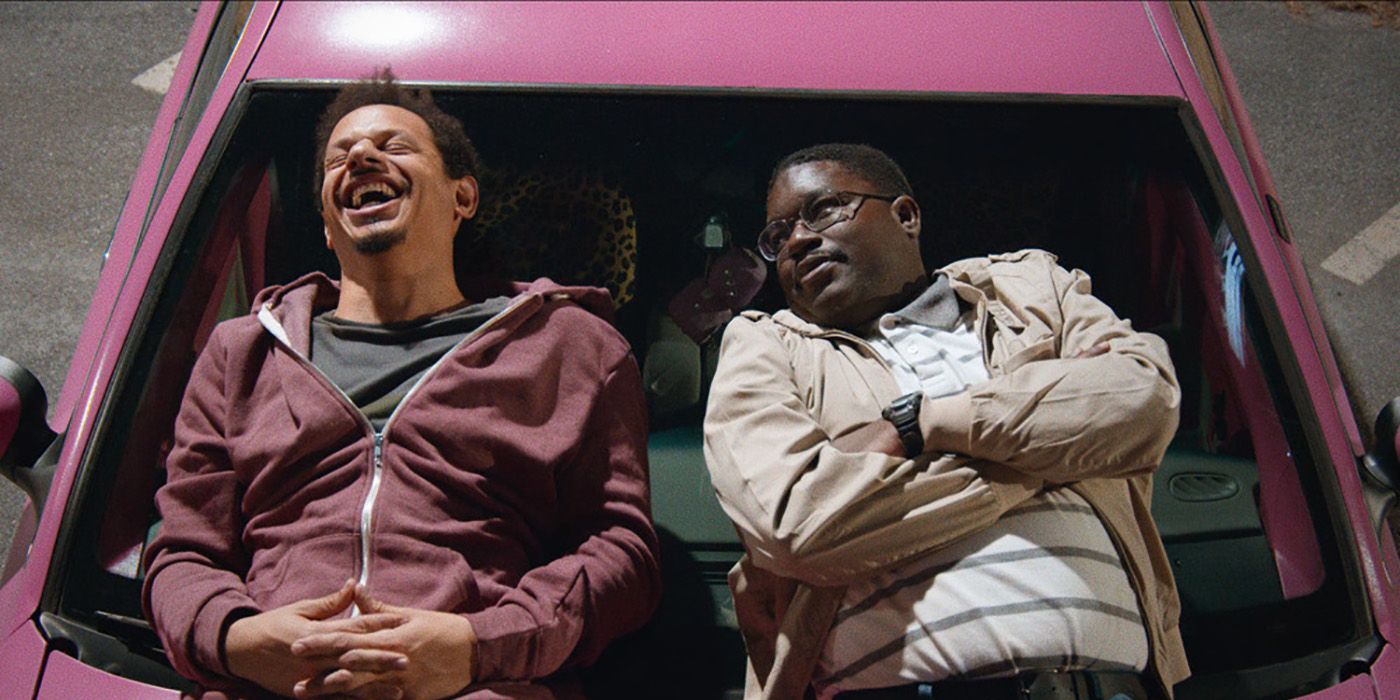 Eric Andre and Lil Rel lying on the hood of a car laughing in Bad Trip