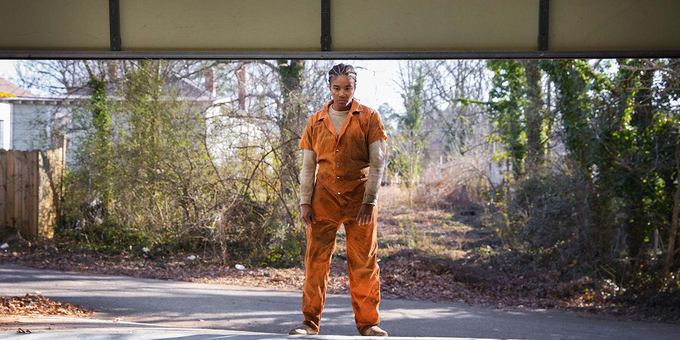 Tiffany Haddish as Trina in Bad Trip, standing under an open garage door in an orange jumpsuit with an angry look on her face