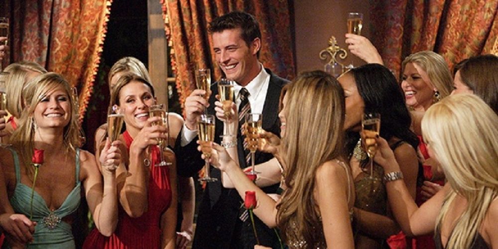 Matt Grant surrounded by The Bachelor participants raising a glass