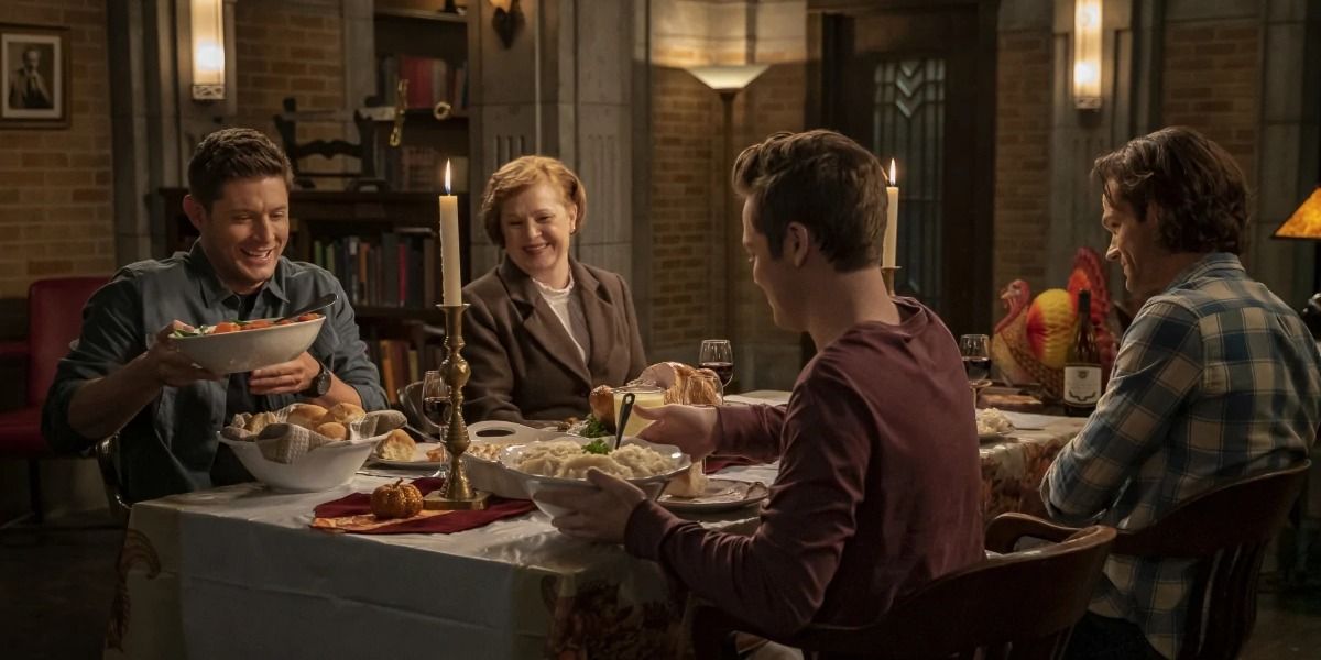 The Winchesters smiling at the table in the dinner scene in the &quot;Last Holiday&quot; episode of Supernatural