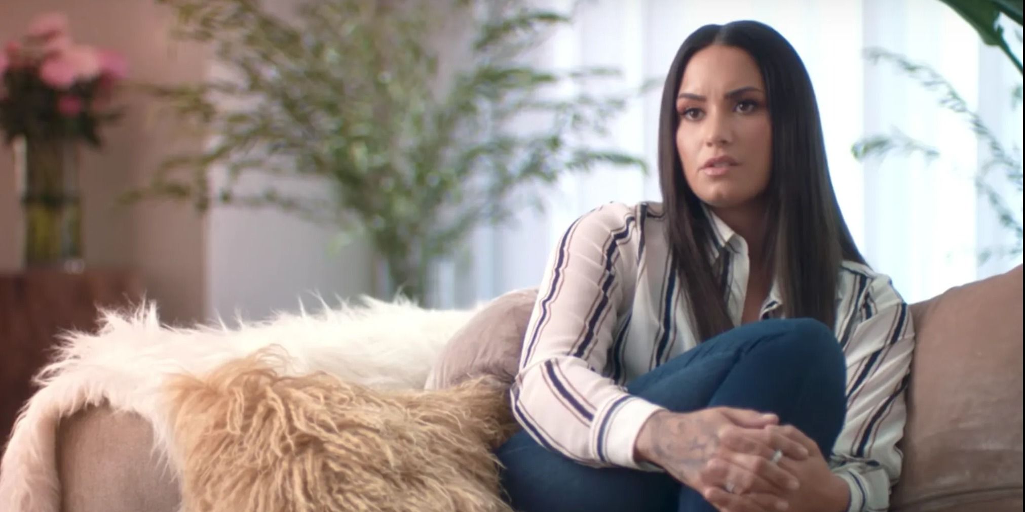 Demi Lovato sitting on a couch in Simply Complicated