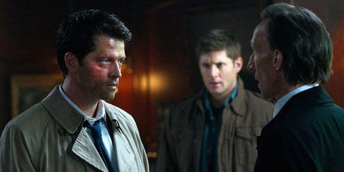 A beat-up Castiel stares at Death with Dean watching in background in Supernatural