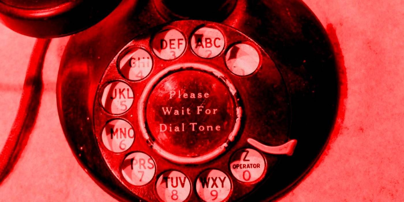 A rotary phone bathed in red light in a promo image for The Black Phone