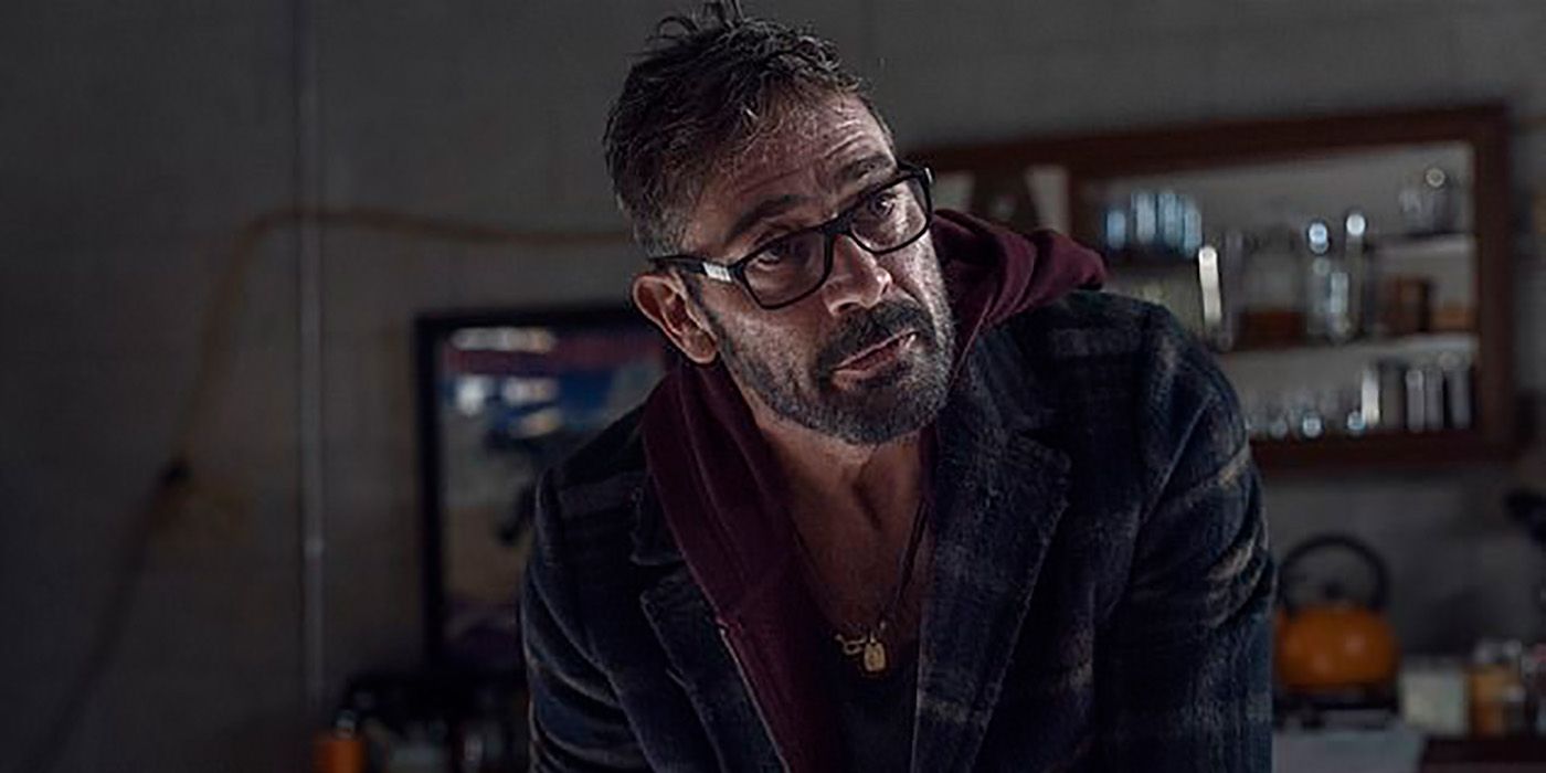 Negan looking up with dark-rimmed glasses and a plaid jacket