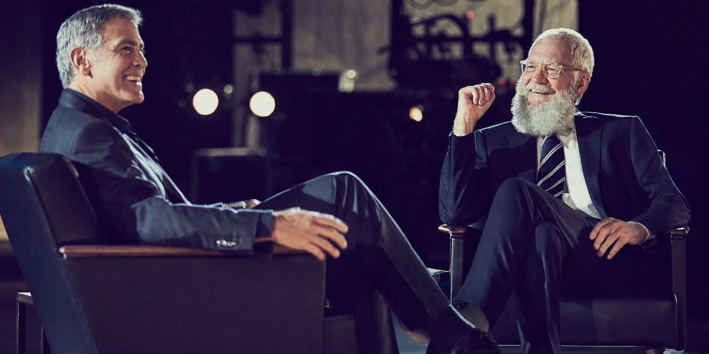 George Clooney and David Letterman laugh on stage on My Next Guest Needs No Introduction