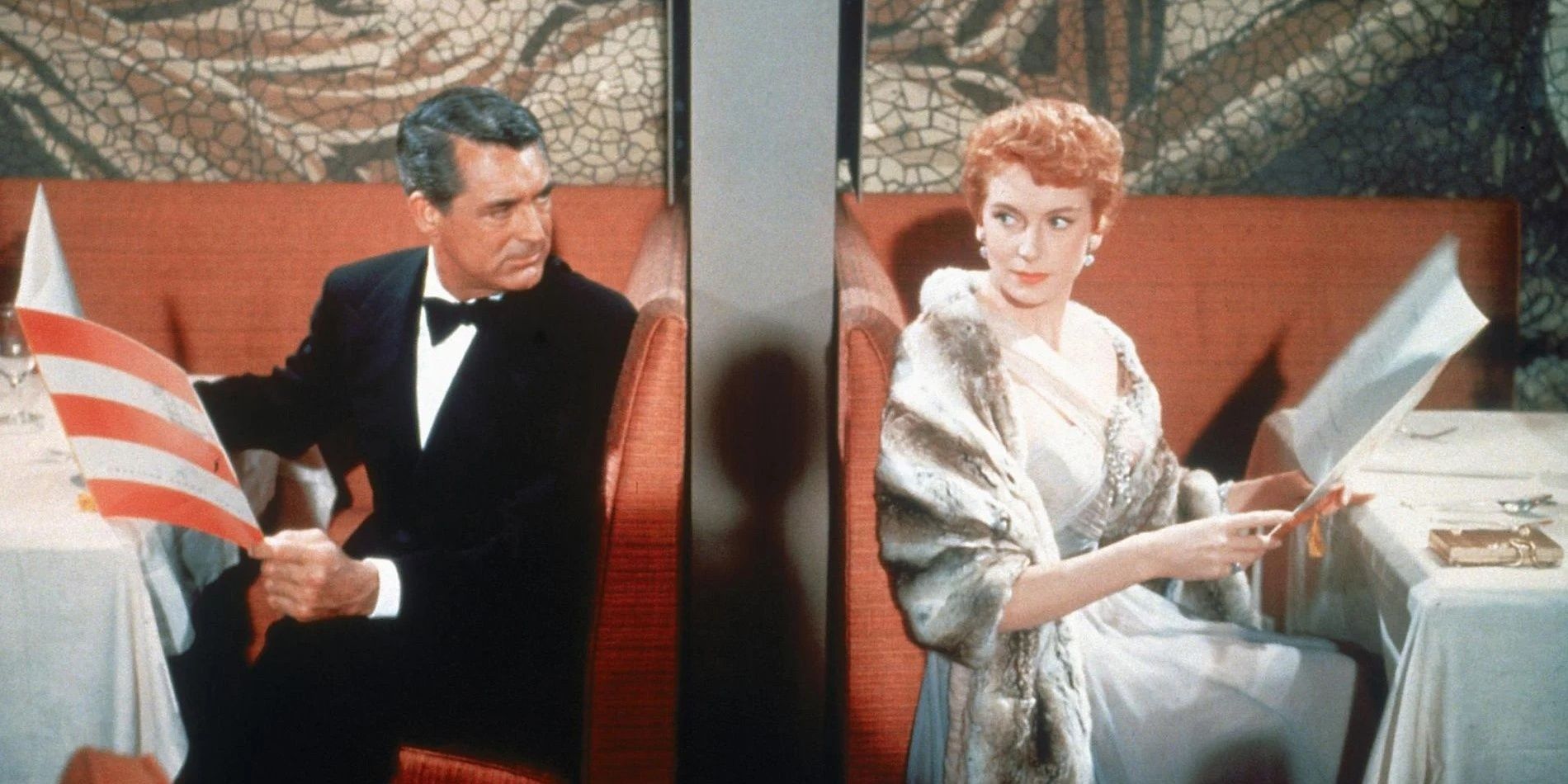 Cary Grant y Deborah Kerr se miran por encima de un tabique en una mesa en An Affair To Remember