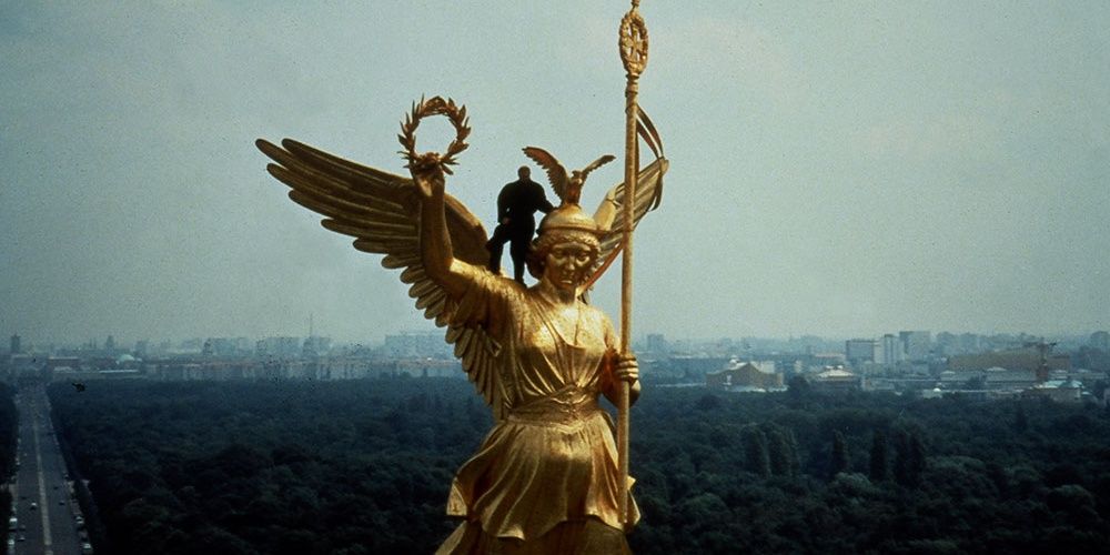 An angel standing on topof a golden angel statue in Berlin, in a still from Faraway So Close 