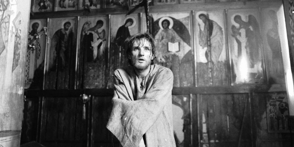 Andrei Rublev standing with his arms crossed in a still from Andrei Rublev