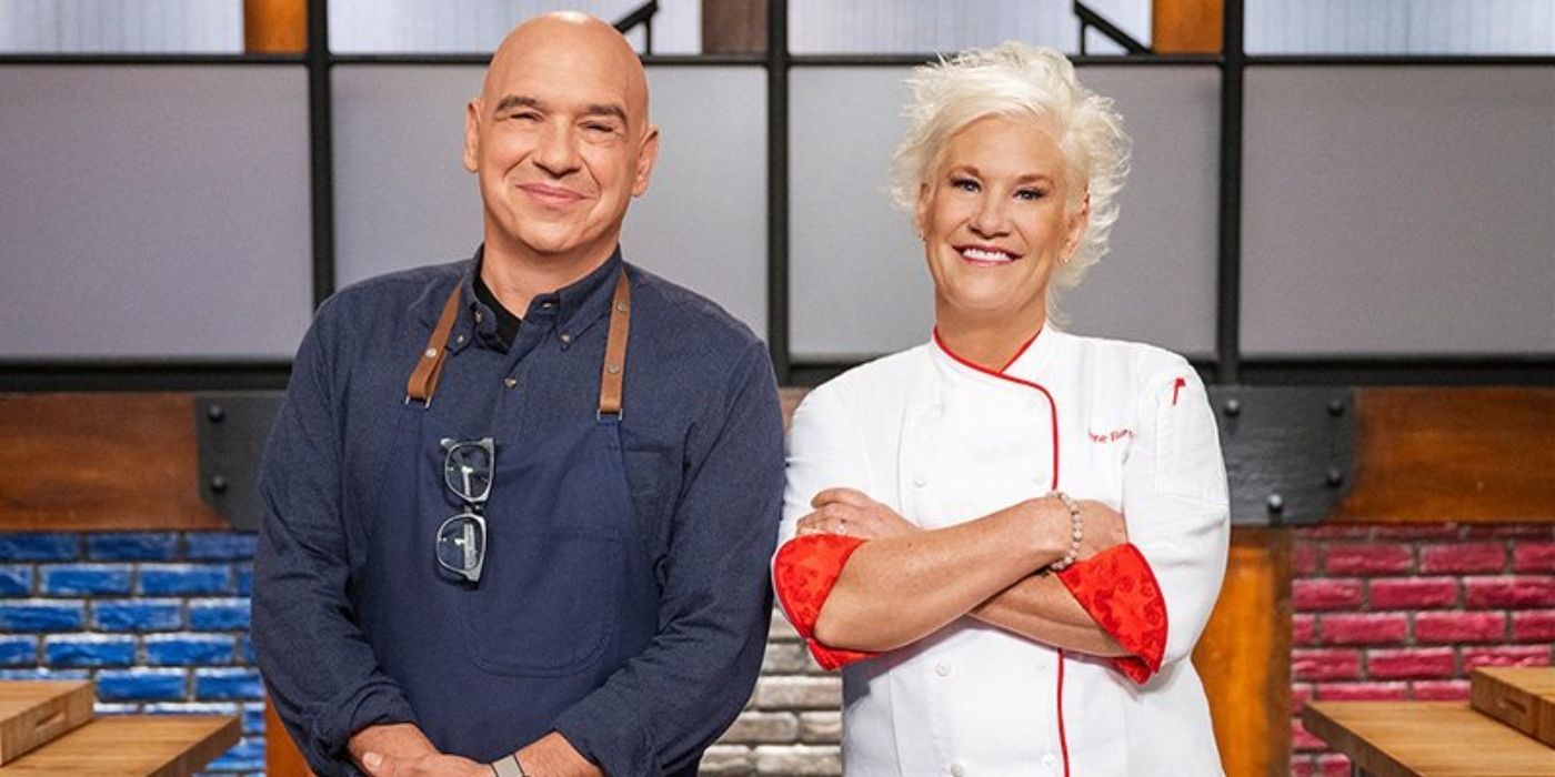 Chefs Anne Burrell and Michael Symon standing together on the set of Food Network's 'Worst Cooks in America.'