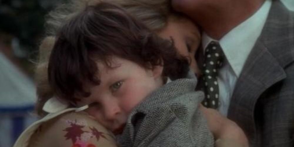 Damien from The Omen being held by his parents.