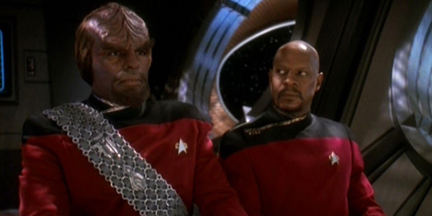 Worf stares off camera while DS9 crew member looks at him questioningly 