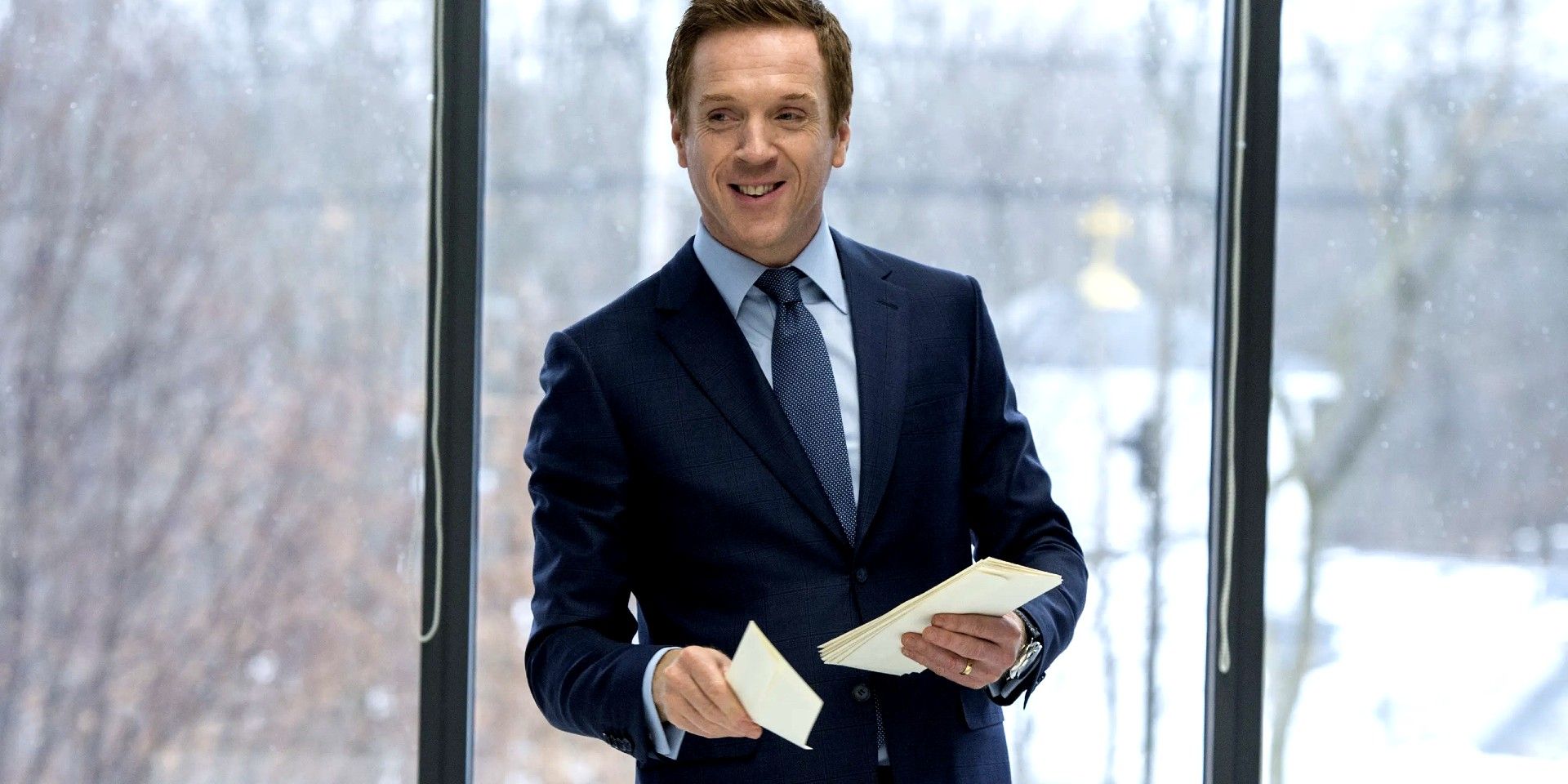 Damian Lewis stands with a slight smile in Billions.