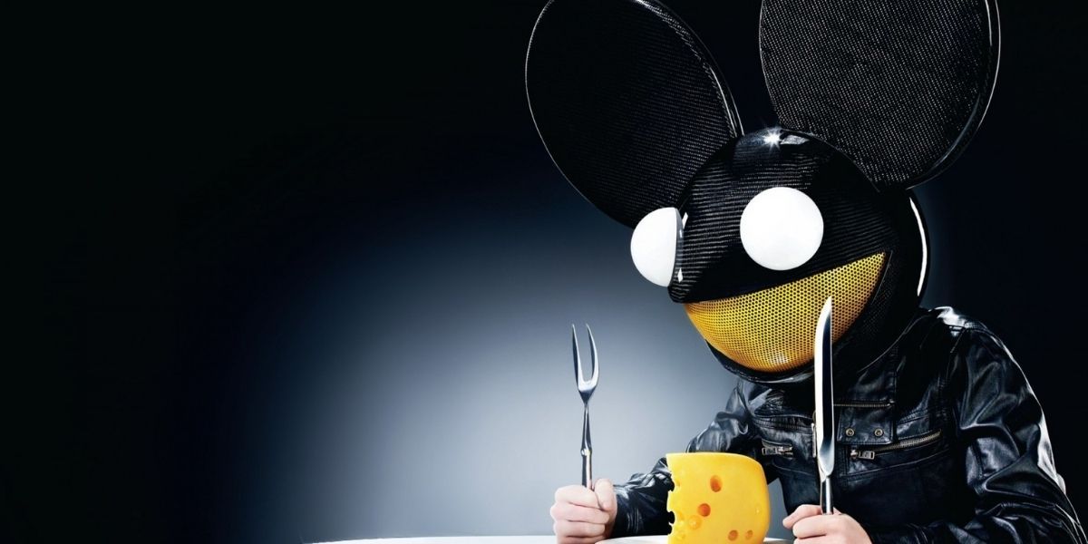 Deadmau5 sitting in a table eating cheese