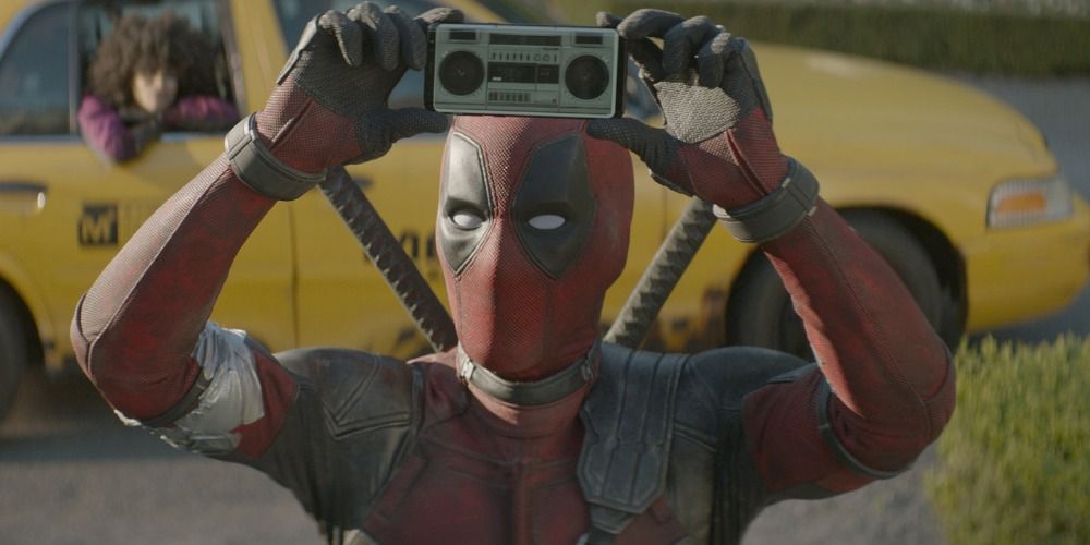 Deadpool holding up a small radio in a scene from Deadpool 2