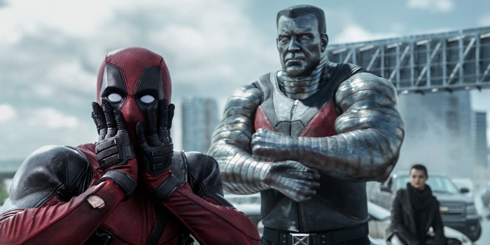 Deadpool holding onto his face while Colossus stands behind him with his arms folded in Deadpool