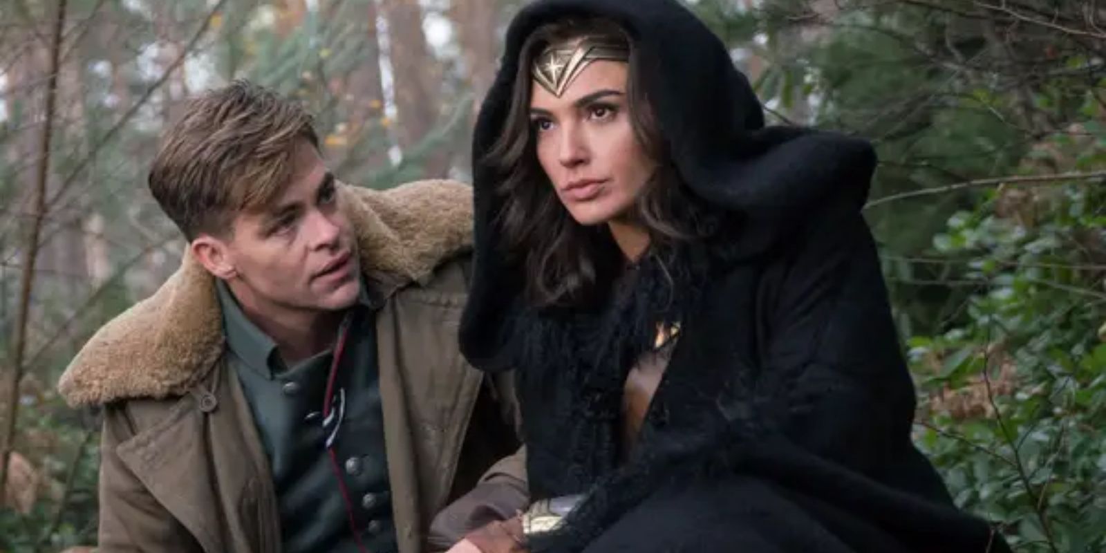 Diana Prince crouches with Steve Trevor in the forest in Wonder Woman
