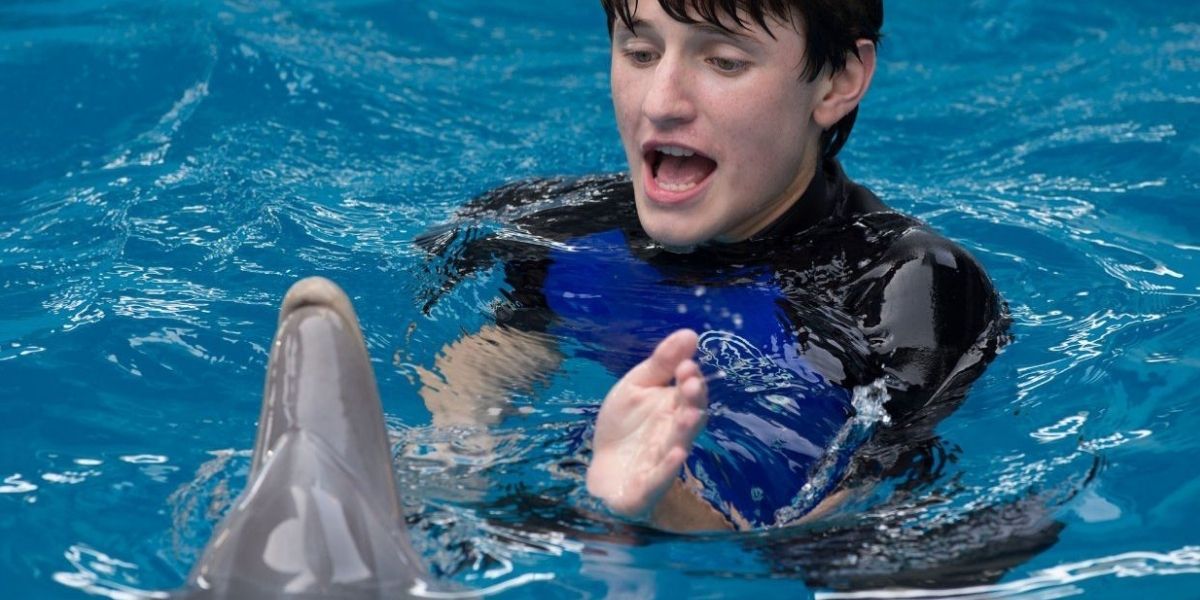 Sawyer in the pool with Winter the Dolphin